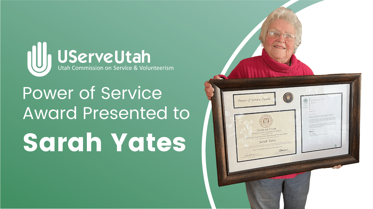 UServeUtah logo. "Power of Service Award Presented to Sarah Yates". Sarah standing with large framed Power of Service Award