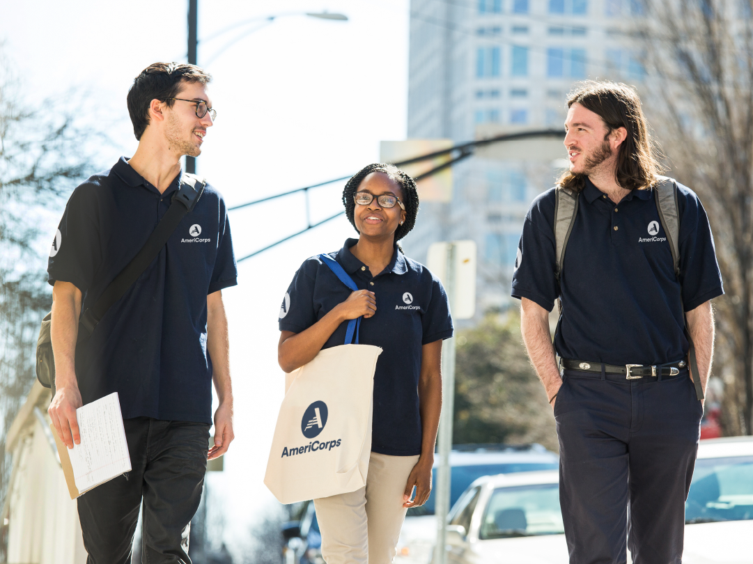 Three AmeriCorps members talking as they walk outside