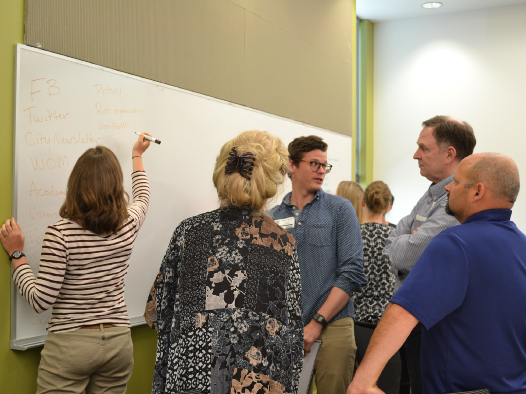 Participants at a Volunteer Management Training writing ideas on a whiteboard