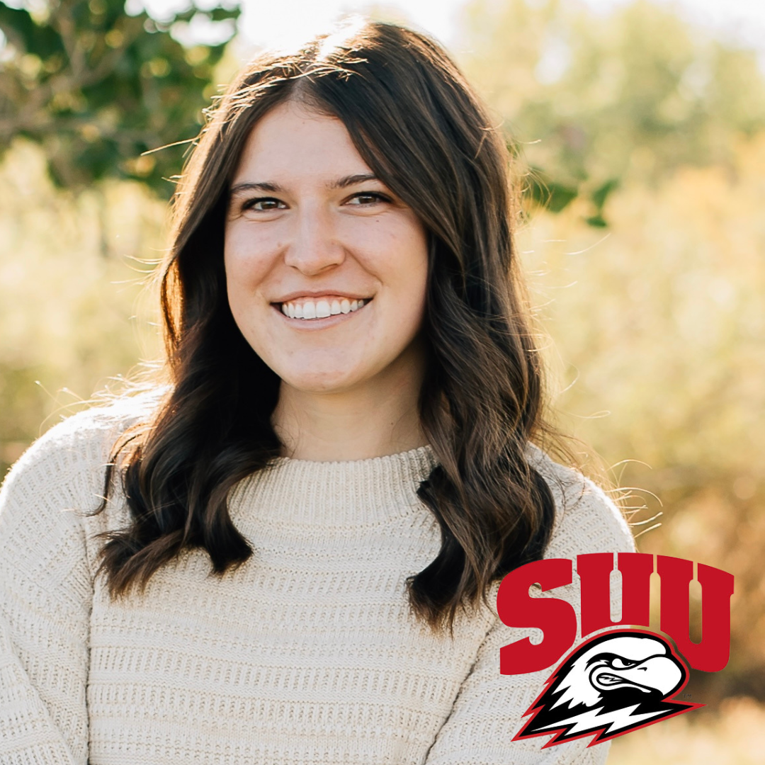 CCEC member Evelin Lagos smiling young woman with long dark curly hair stands outdoors in front of cement wall wearing a light colored blouse and necklace. Includes Utah Valley University's wolverine icon.