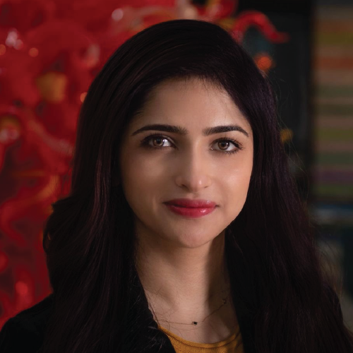 Woman with long dark hair and a neutral expression standing in front of a red abstract background.